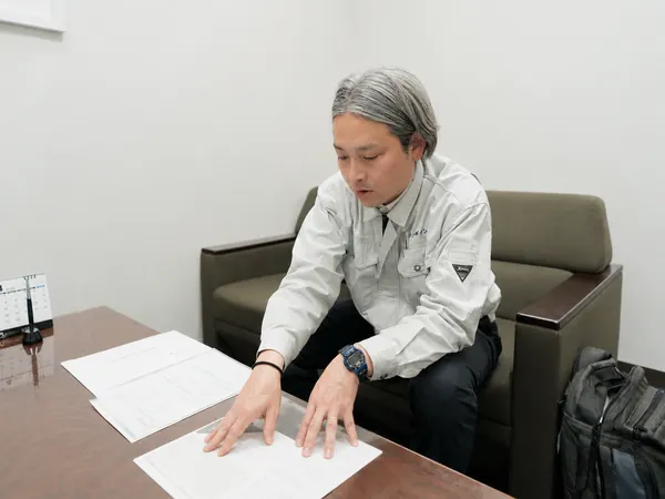 届いた相談内容の書類を確認する営業社員